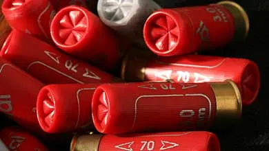 Pile of red shotgun shells, brass bases, crimped tops.