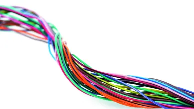 Multi-colored wires, twisted into a bundle, against a white background.