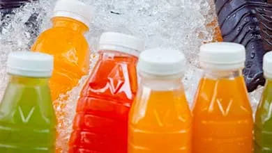 Assorted sealed beverage bottles in multiple colors displayed on ice, representing packaged drink preservation.